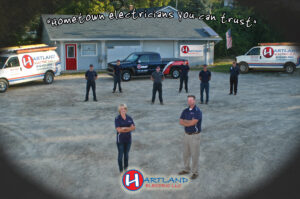 Hartland Electric - a group of people standing in front of their office