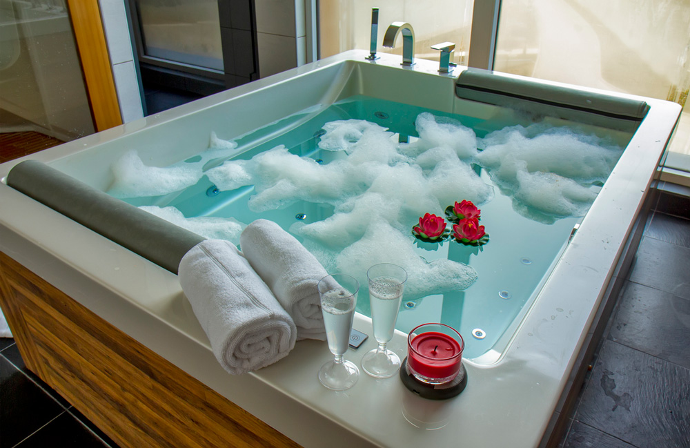 a bathtub filled with foam and flowers.